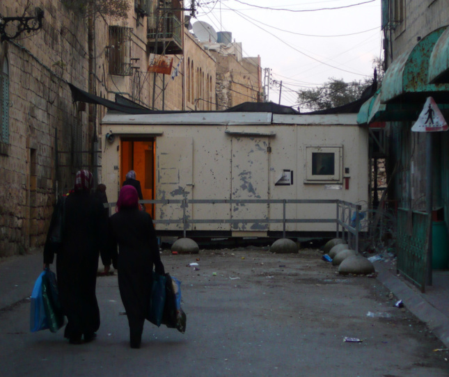 以色列国防军士兵把守的检查站封锁了Shuhada街的入口，Shuhada街是希伯伦老城以前重要的巴勒斯坦市场街道。