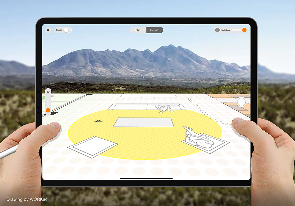 手举着iPad Pro在一座山前，可以看到一个比例的CAD绘图投影。