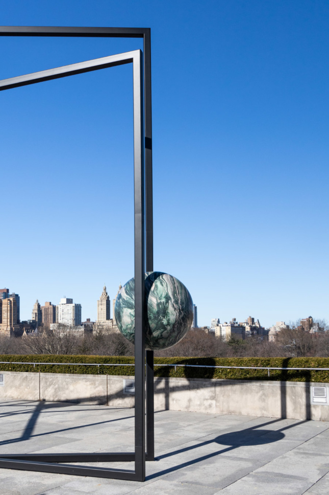 纽约大都会博物馆屋顶上的雕塑中悬挂的石球的照片