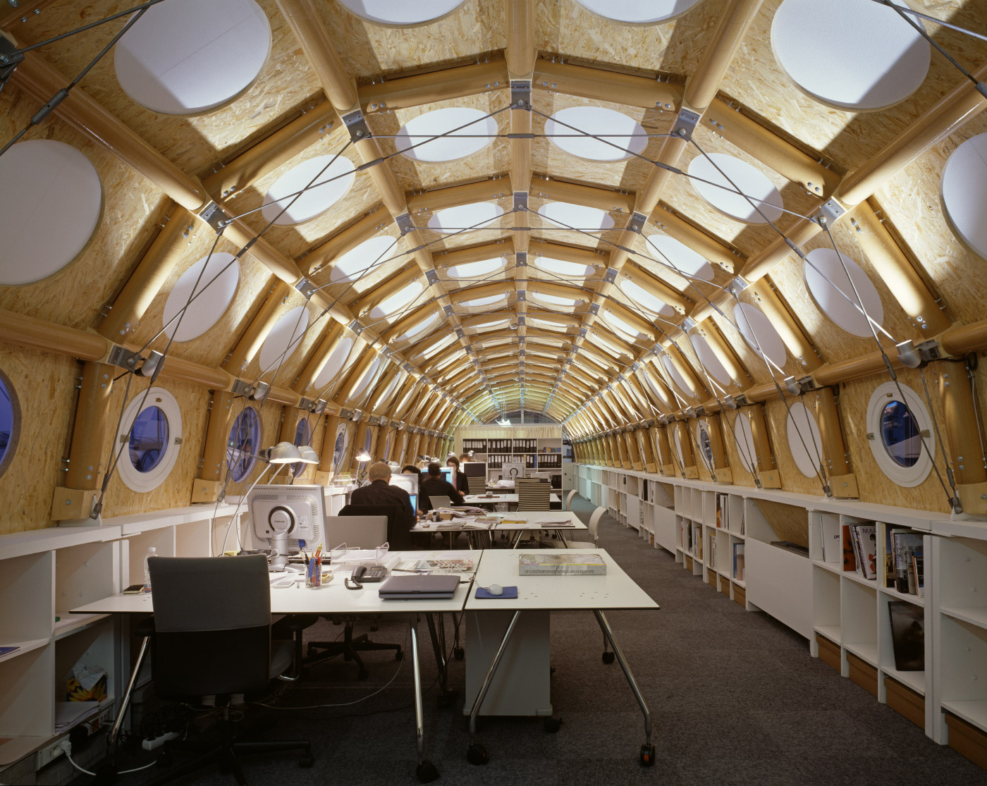 在纸板管做成的半圆形空间内的移动办公室的照片