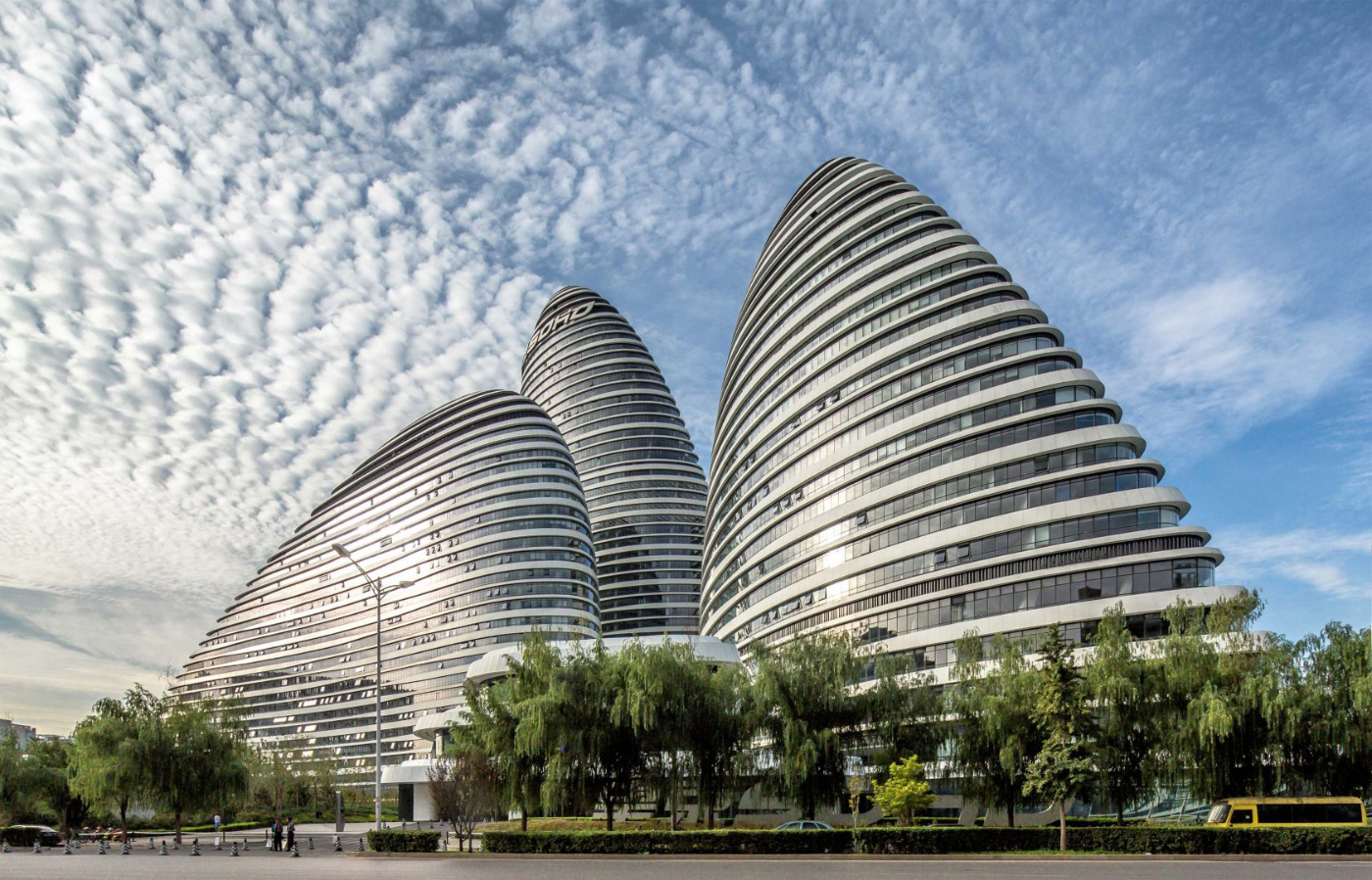 在晴朗的天空下，三座圆形的卵石状办公大楼的照片