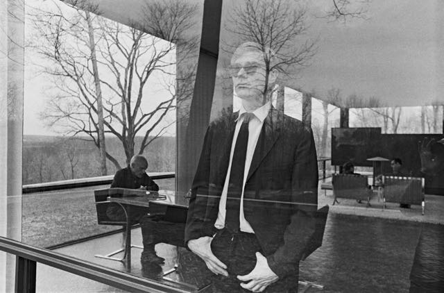 安迪·沃霍尔从玻璃屋的窗户往外看的照片