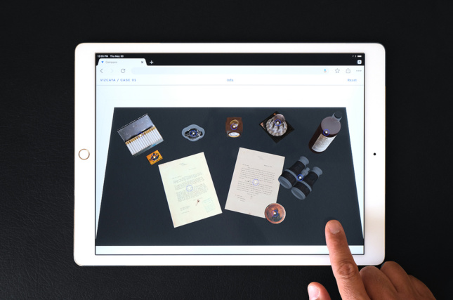 iPad可以显示一系列物品——信件、烟盒、双筒望远镜等。