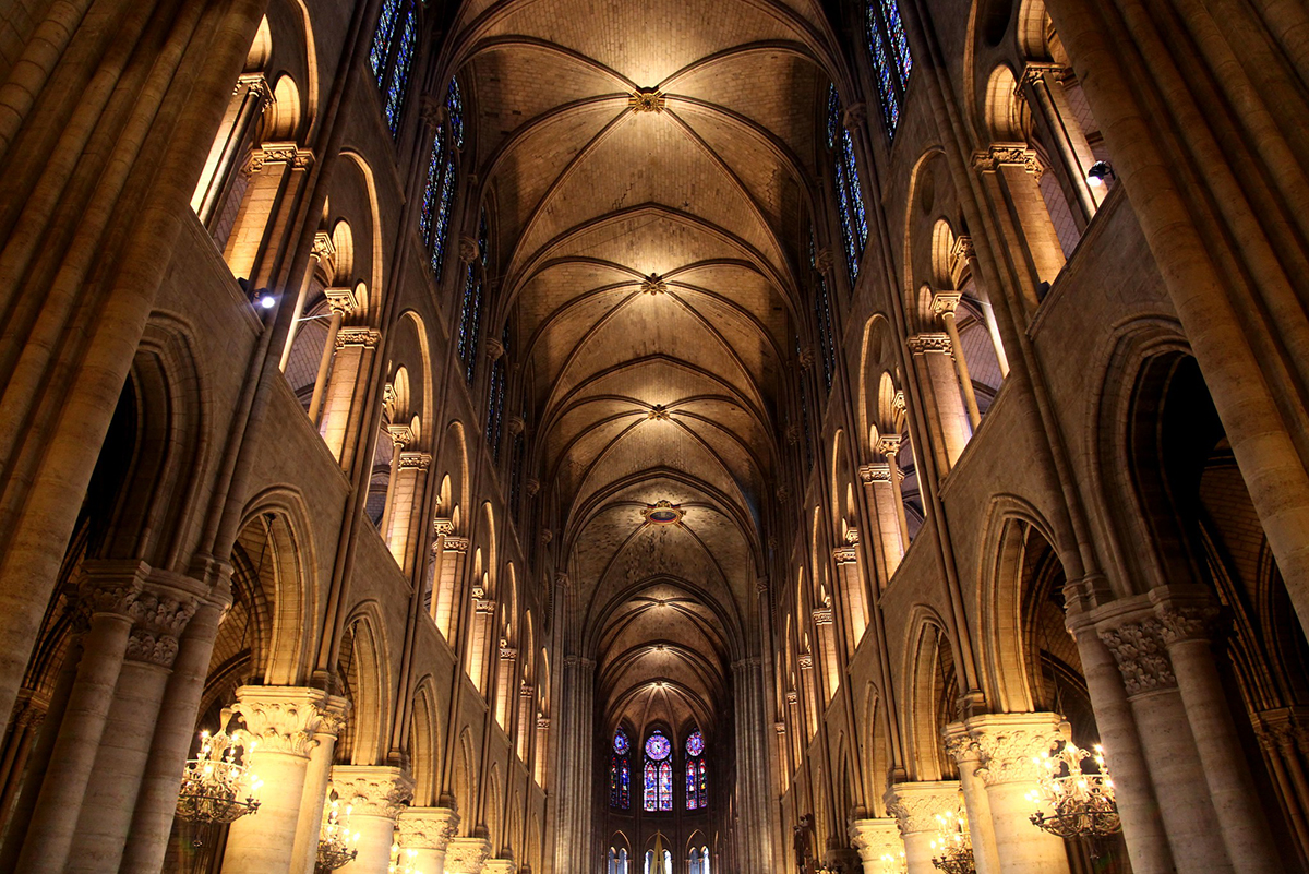 巴黎圣母院内部的图像与蜡烛照亮的拱顶和柱子