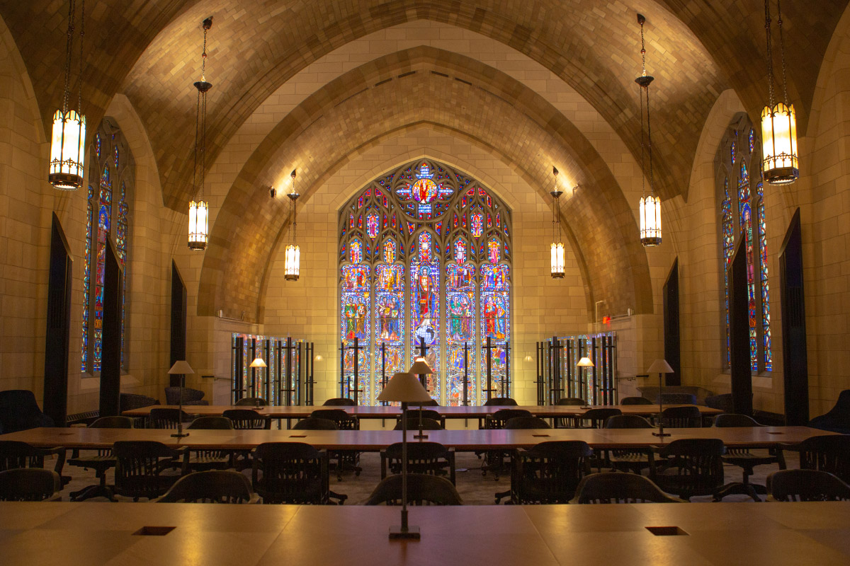 A stained glass window in front of a row of workstations