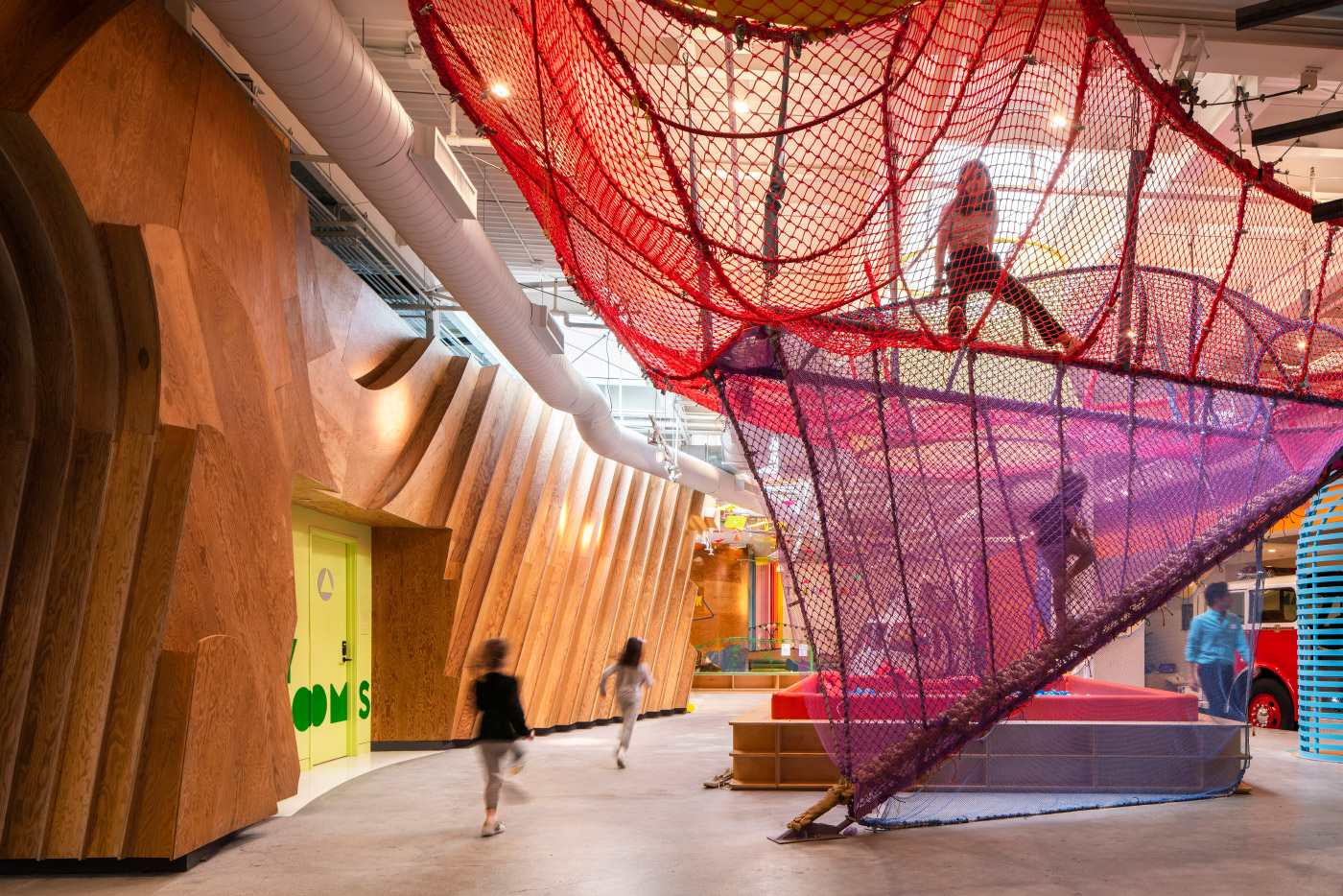 在凯顿儿童博物馆的一个空间里，孩子们在五颜六色的网里奔跑