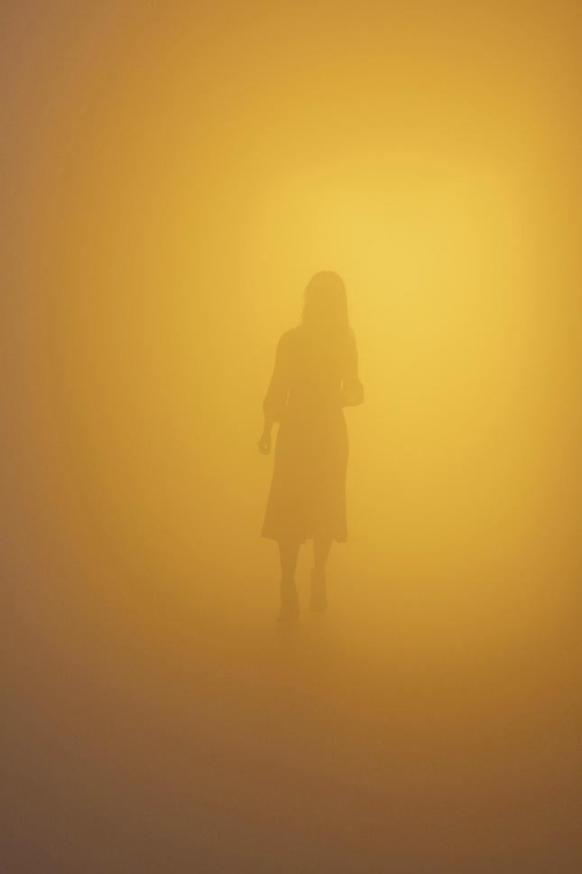 一个女人在橙色的雾中徘徊