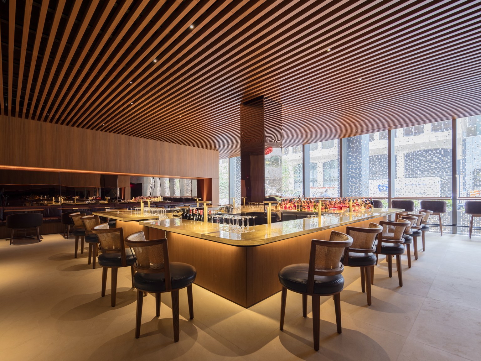 新四季酒店(Four Seasons)一间温暖质感的酒吧室内，天花板为木质