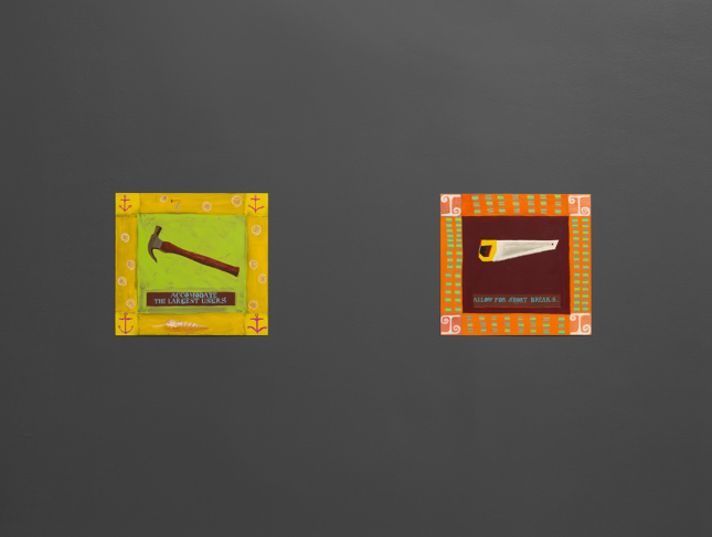 新博物馆的墙上挂着两个小正方形的图像，一个是锤子，另一个是锯子
