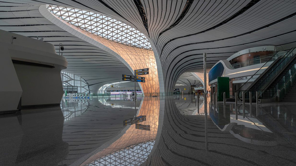 机场内部照片，光滑的白色地板和弧形墙壁上的大天窗，旁边是北京大兴国际机场办理登机手续