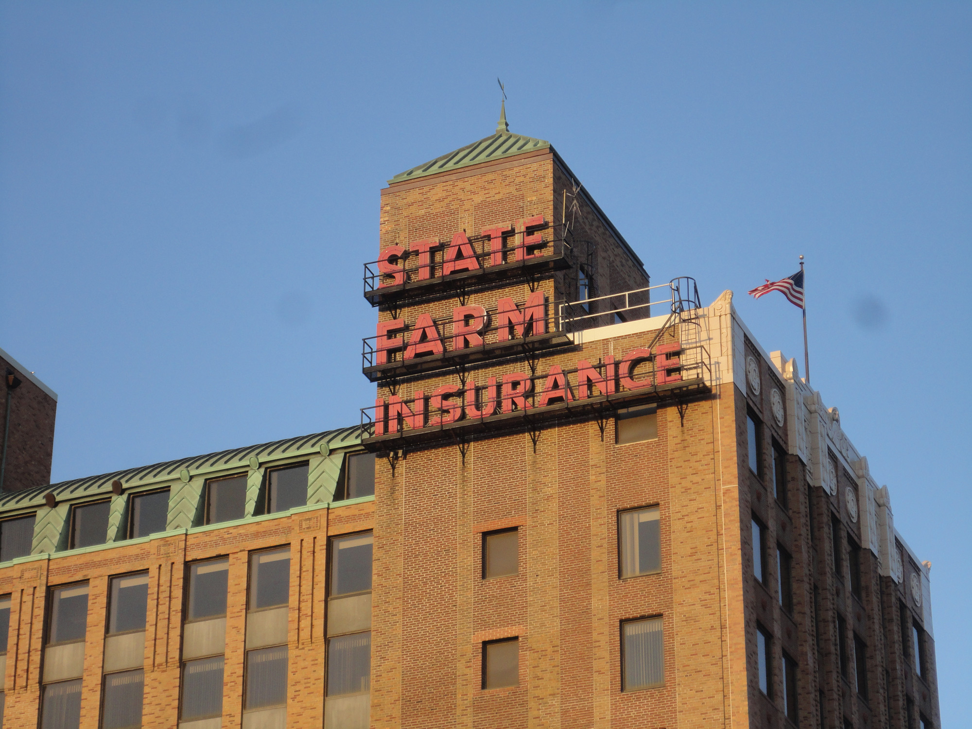 在棕色砖石建筑的顶部，在鲜红色帽子的国家农场保险公司。