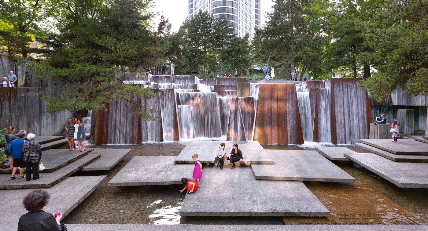 儿童在大型城市喷泉中玩耍的图片，喷泉有方形平台和瀑布，来自文化景观基金会