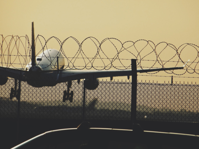 希思罗机场围栏后起飞的飞机照片