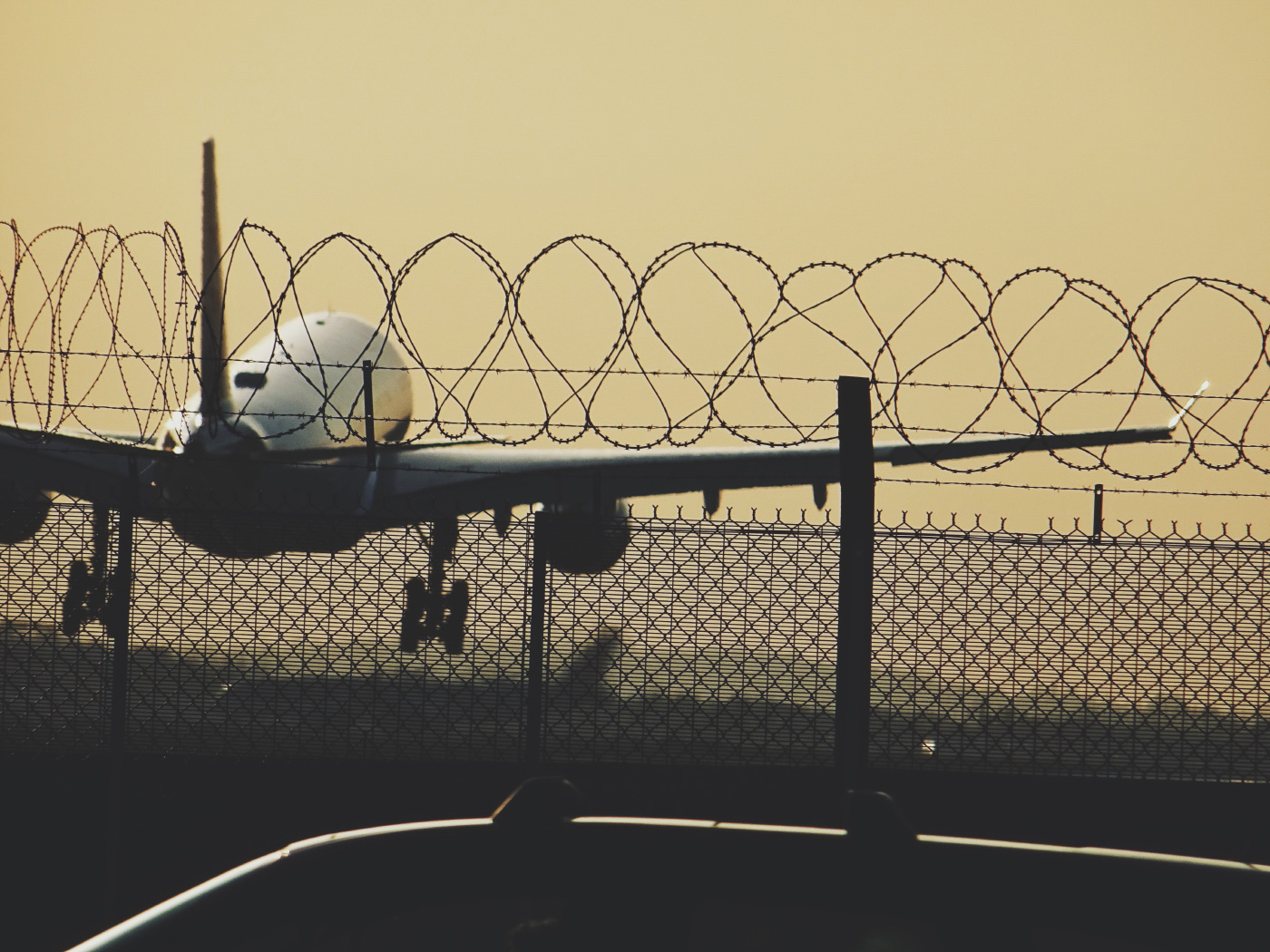 图为一架飞机在希思罗机场的围栏后起飞