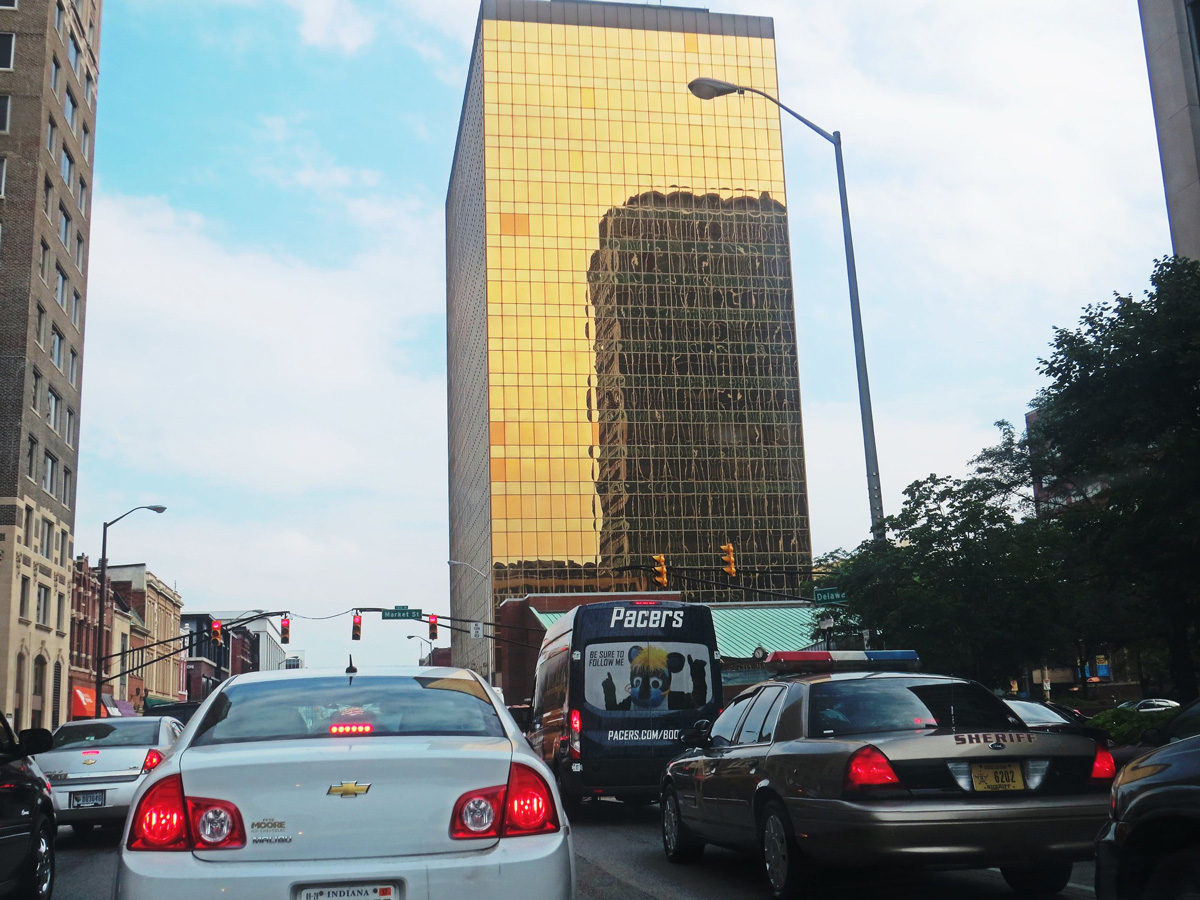 金色玻璃包裹的建筑前的交通