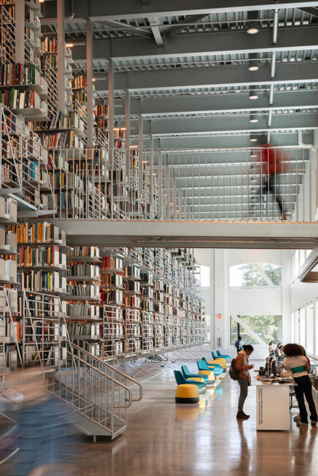 图书馆内部的垂直镜头，人们走上t台走向书架