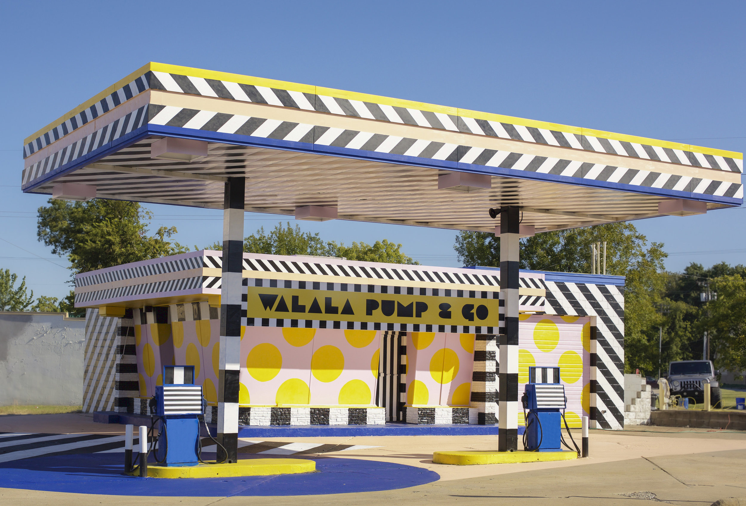 艺术家卡米尔·瓦拉拉把一个加油站变成了这个粉红色和黄色的公共艺术作品。