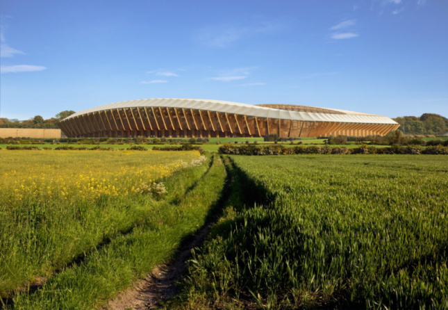 一座木结构的足球场坐落在一片蓝天下的田野上