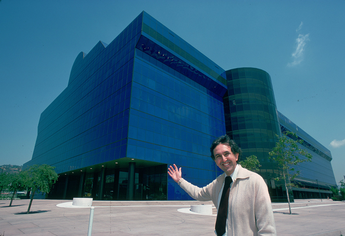 男子站在蓝色玻璃建筑前的形象