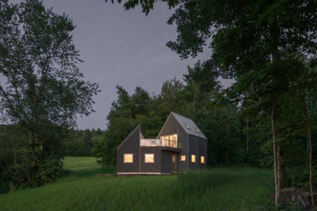 佛蒙特州一间小屋在黄昏时映衬着绿色景观的照片