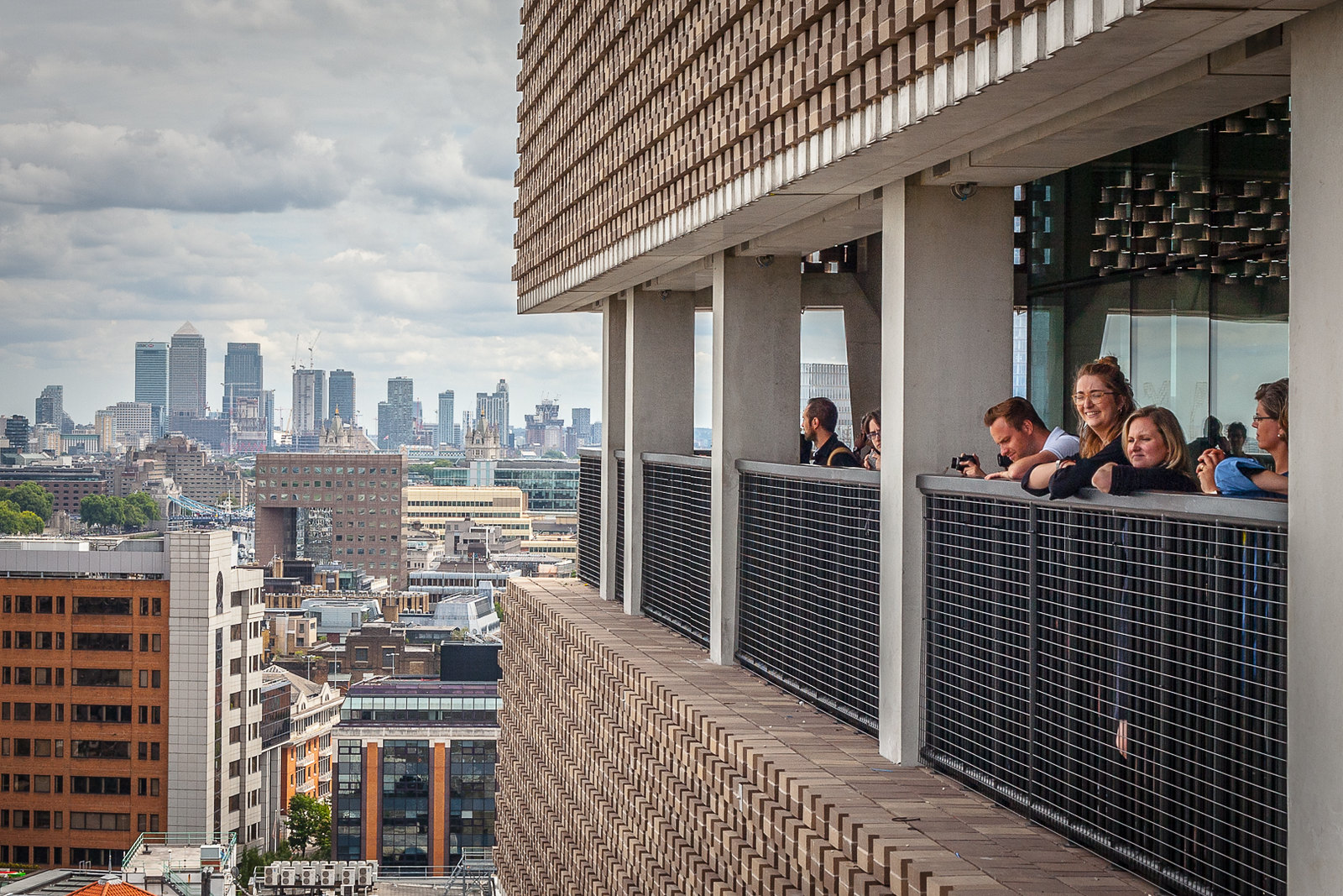 在伦敦泰特现代美术馆的阳台上，人们悬在栏杆的边缘
