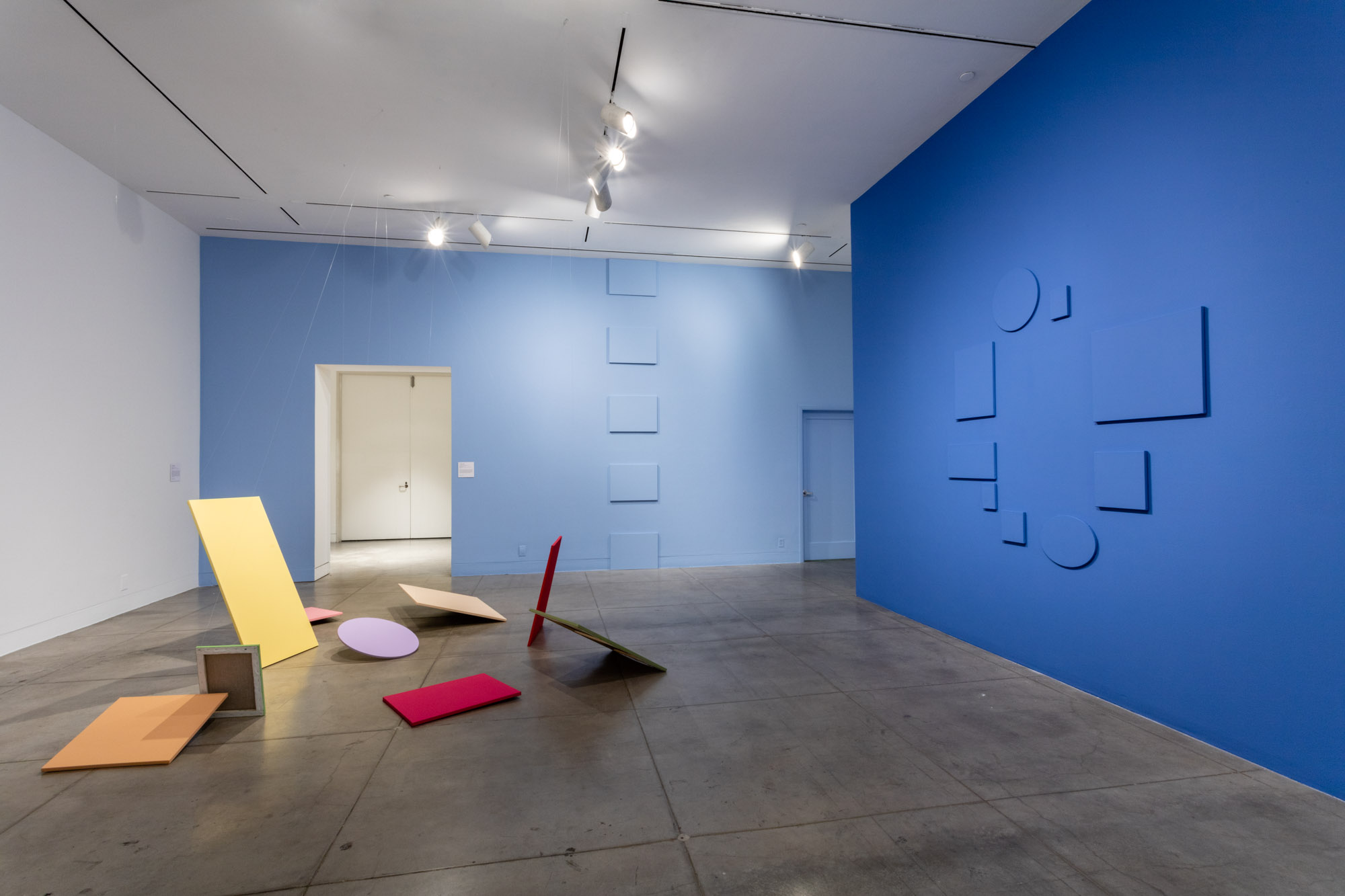 画廊的内部，蓝色的墙壁上挂着克劳德·鲁托(Claude Rutault)的画作