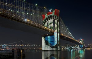 布鲁克林大桥在夜晚灯火通明，自由女神像投射在桥上