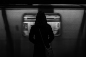 一个人等待MTA地铁列车的灰度照片