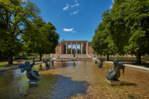前景有一个大水池和喷泉的学术建筑
