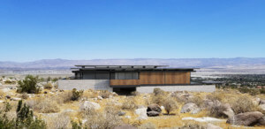 Exterior rendering of a low slung home against the desert of palm springs for modernism week