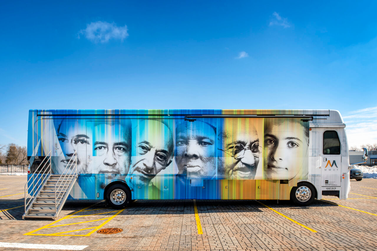 一辆巴士，“流动宽容博物馆”，上面画着人脸