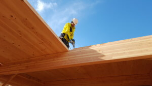 一个建筑工人站在木屋顶上
