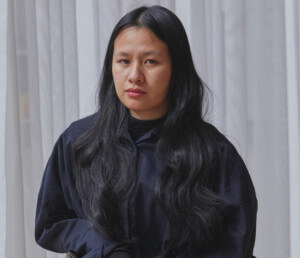 Trang Tran，一位年轻的亚裔美国女性，在椅子上摆姿势