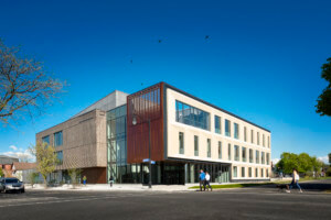 德尤维尔卫生专业中心的外观，这是一座以玻璃为核心的对开的石头建筑