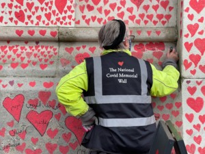 一名工人在covid纪念墙上添加了一颗心脏
