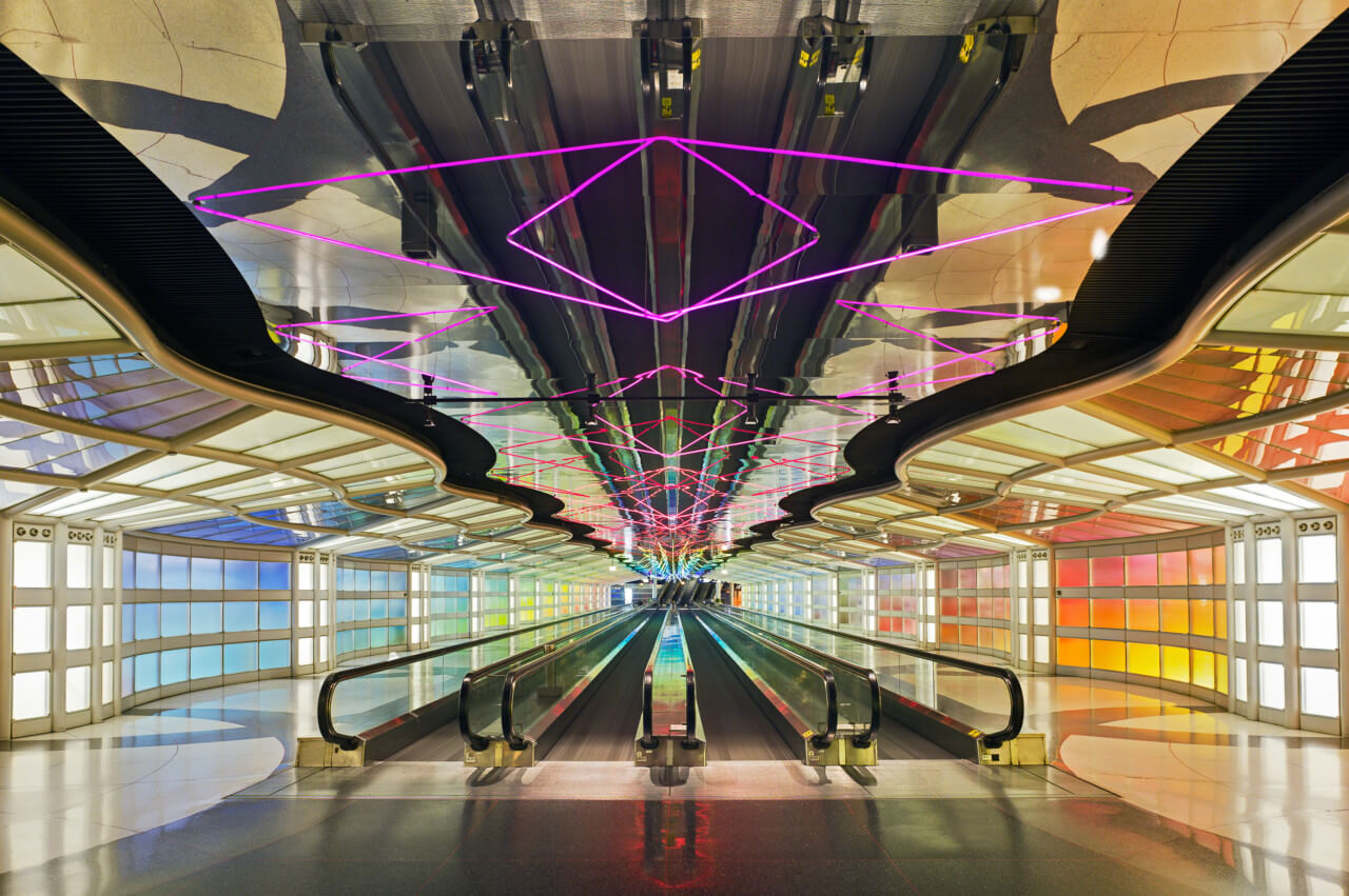 由helmut jahn设计的紫色霓虹灯管和彩色侧墙的机场大厅内部照片
