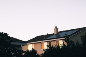 黄昏时拍摄的屋顶安装了光伏电池板的住宅，不受加州太阳能新法令的约束