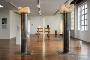 野口博物馆展出的无用建筑内部照片，展示了两根雕刻柱之间的雕塑