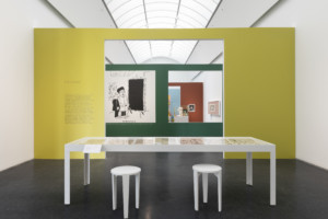 这张照片描绘了一个博物馆画廊，隔断墙漆成黄色、绿色、红色和蓝色