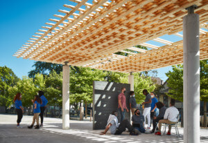 学生们聚集在一个木材亭子下，SPLAM，有一个木制框架的格子顶层原型