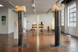 野口博物馆展出了这座无用建筑的内部照片，展示了两根雕刻柱子之间的雕塑
