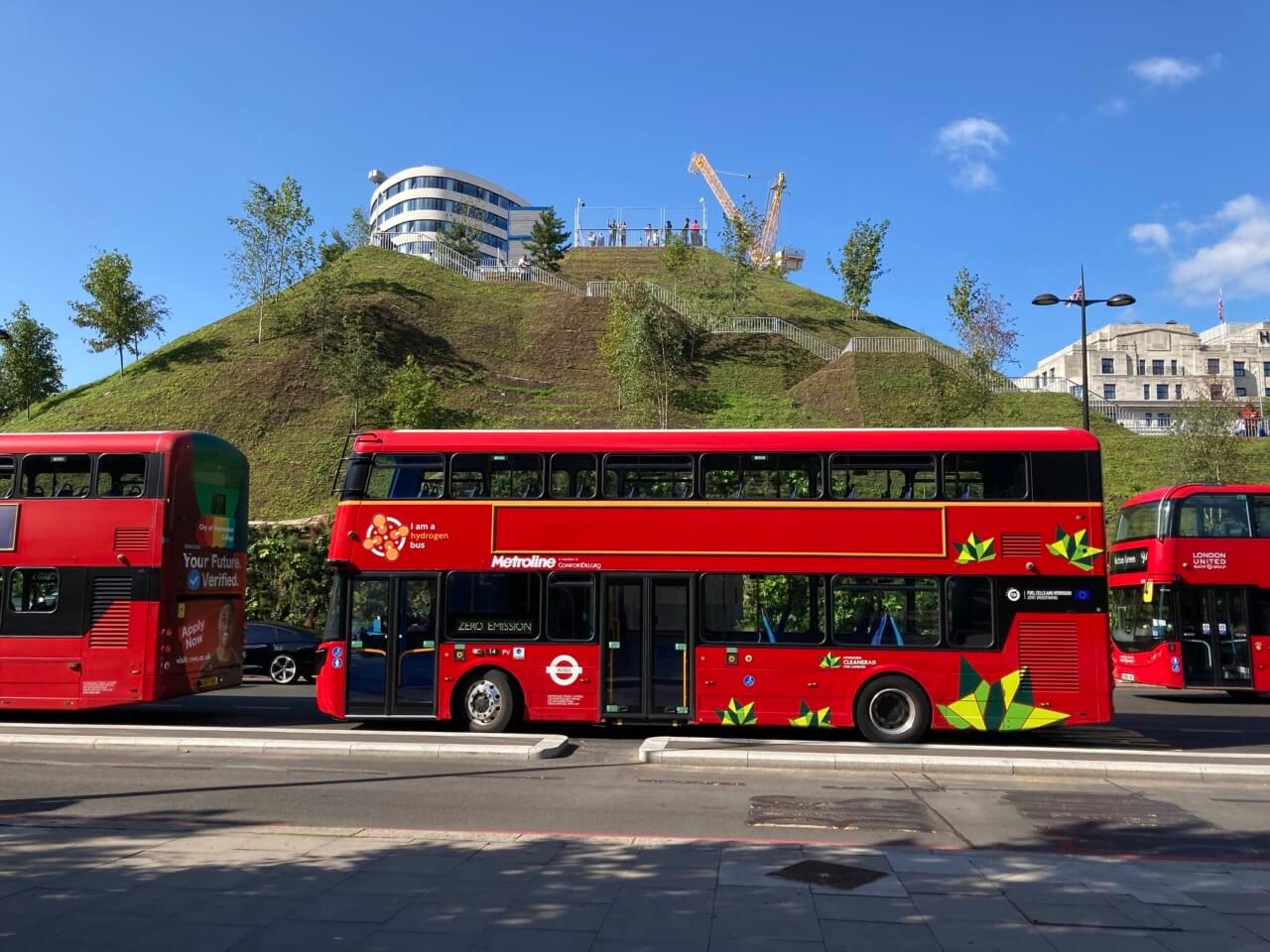 伦敦旅游巴士前有一座人造山头，大理石拱顶土堆