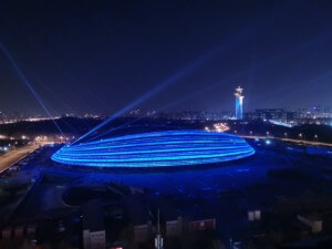 一个椭圆形的竞技场建筑被蓝光照亮