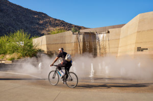 一名男子骑着自行车经过一处雾蒙蒙的水景