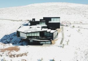 the dark chalet, an all black house, covered in snow