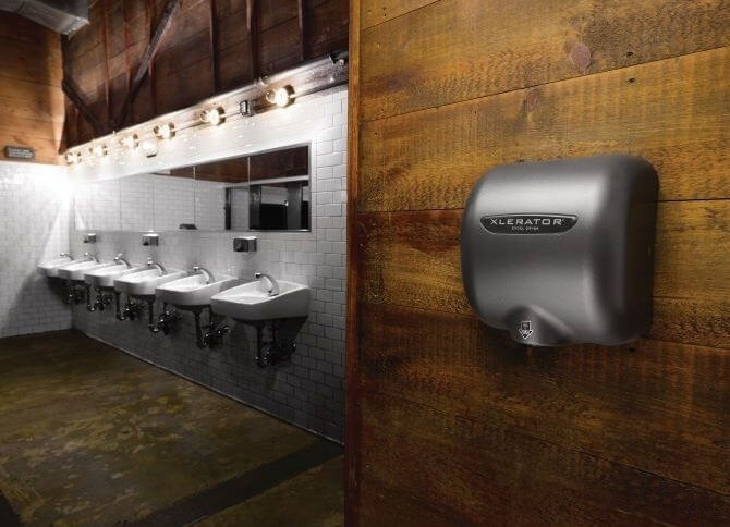 在有6个水槽的公共浴室的木墙上放置干手器