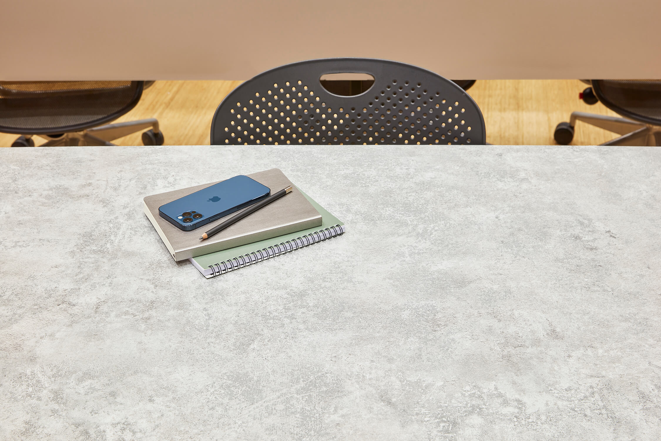 IPhone铅笔和笔记本放在灰色的混凝土桌面上