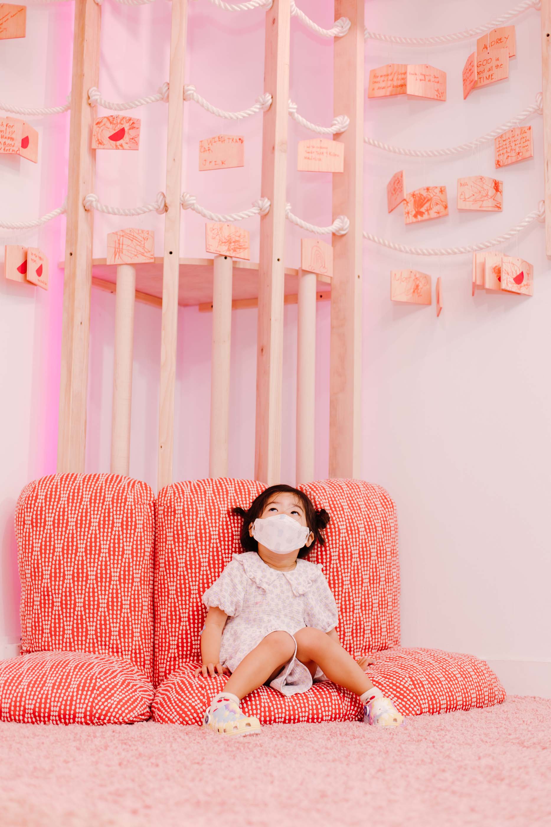 孩子坐在粉红色的垫子上