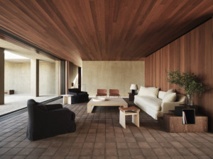 房间里有白色沙发和黑色椅子，墙壁和天花板上有木镶板