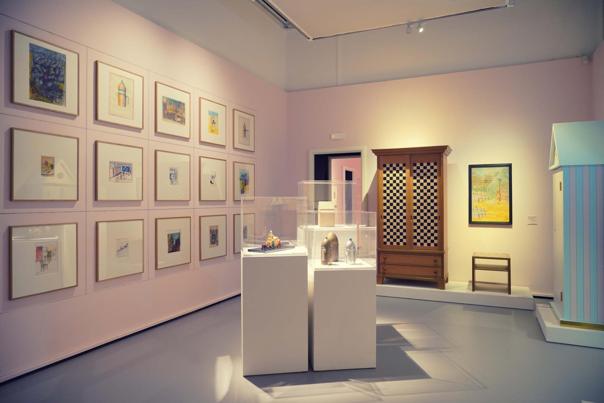 粉红色的墙壁和展示的素描和物品的展览室